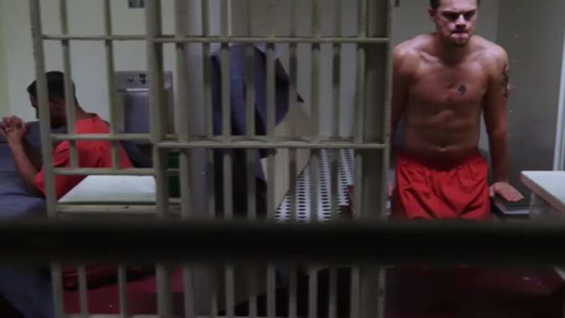 Leonardo Di Caprio shirtless in a prison cell
