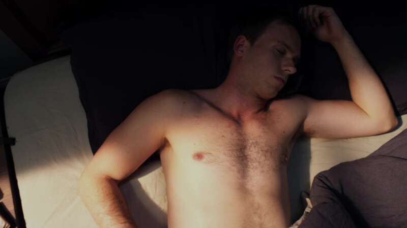 Shirtless actor Patrick J. Adams wakes up in bed